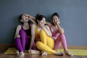 three asian woman wearing yoga suit sitting in fitness room photo