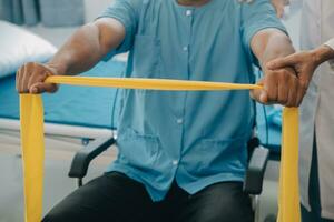 Doctor or Physiotherapist working examining treating injured arm of athlete male patient, stretching and exercise, Doing the Rehabilitation therapy pain in clinic. photo