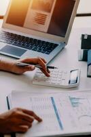 businessman working on desk office with using a calculator to calculate the numbers, finance accounting concept photo