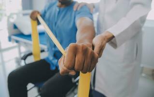 Physical therapist guiding patient with resistance band photo