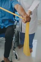 Physical therapist guiding patient with resistance band photo