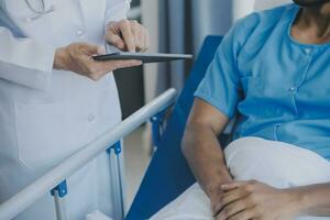 Doctor and patient discussing current health examination while sitting at the desk in clinic office, closeup. Medicine concept. photo