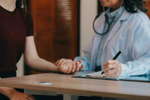 Asian doctor woman visited patient woman to diagnosis and check up health at home or private hospital. Female patient explain health problem and symptoms to doctor .Health care premium service at home photo