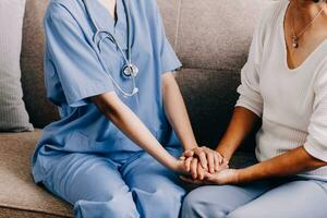 Happy senior woman visiting doctor, getting optimistic news after medical checkup, therapy. Therapist holding hand of old patient, giving hope, support, congratulating on goor treatment result photo