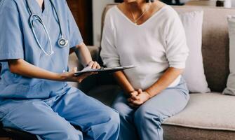 Serious GP doctor showing tablet screen to old 70s female patient, explaining electronic prescription, medical screening, examination result, giving consultation. Woman visiting practitioner photo