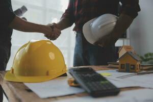 Close up of civil male engineer asian working on blueprint architectural project at construction site at desk in office. photo