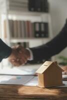 Real estate brokerage agent Deliver a sample of a model house to the customer, mortgage loan agreement Making lease and buy and sell house And contract home insurance mortgage loan concept photo