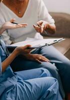 Doctor showing medical card to patient at table in clinic, closeup photo