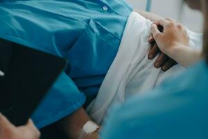 Injured patient showing doctor broken wrist and arm with bandage in hospital office or emergency room. Sprain, stress fracture or repetitive strain injury in hand. Nurse helping customer. First aid. photo