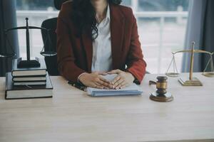 Business and lawyers discussing contract papers with brass scale on desk in office. Law, legal services, advice, justice and law concept picture with film grain effect photo