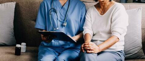 Caring doctor teaches female patient to use mobile healthcare app. Retired lady sitting in hospital exam room looking at cell screen learning to download health tracker for senior citizens. Copy space photo