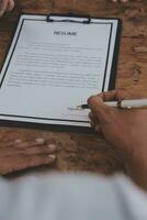Close up view of job interview in office, focus on resume writing tips, employer reviewing good cv of prepared skilled applicant, recruiter considering application, hr manager making hiring decision photo
