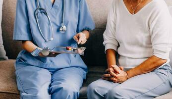 médico y paciente sentado y hablando a médico examen a hospital oficina, de cerca. terapeuta relleno arriba medicación historia registros. medicina y cuidado de la salud concepto. foto