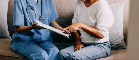 Doctor showing medical card to patient at table in clinic, closeup photo