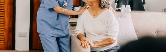 Happy young female nurse provide care medical service help support smiling old grandma at homecare medical visit, lady carer doctor give empathy encourage retired patient sit on sofa at home hospital photo