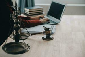 Justice and law concept.Male judge in a courtroom with the gavel, working with, computer and docking keyboard, eyeglasses, on table in morning light photo
