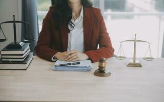 Business and lawyers discussing contract papers with brass scale on desk in office. Law, legal services, advice, justice and law concept picture with film grain effect photo