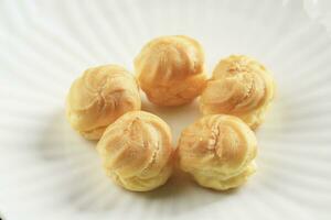 Close Up Profiteroles with Whipped Cream and Chocolate Filling. photo