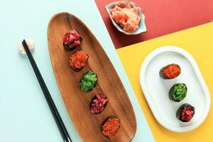 Various Set of Gunkan Sushi on Colorful Table photo