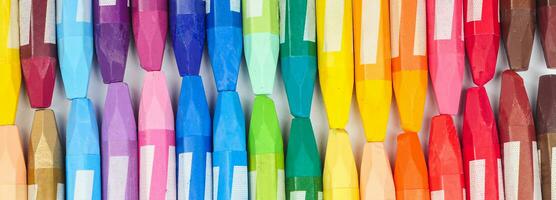 a collection of neatly arranged crayon sticks visible from above in a row of colorful colors photo