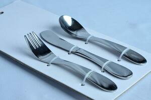 forks spoons and knives eating utensils are neatly arranged in a paper board panel packaging photo