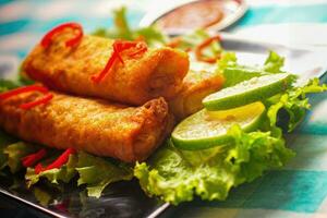 Lumpia or lunpia traditional snacks from Semarang, Central Java, Indonesia. Traditional spring rolls contain stir-fried bamboo shoots rebung, eggs, and chicken or shrimp. photo