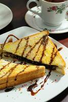 A pieces of cake for breakfast in a plate with a cup of tea photo