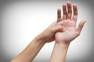 Woman suffering from palm pain, or finger pain. Hand numbness or limb numbness. Isolated on white. Pain concept. photo