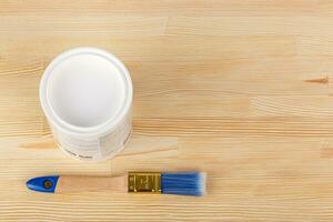 white paint with a brush on a wooden background with texture photo