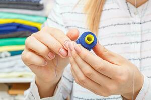 Adjusting the sewing machine, threads in female hands photo