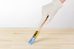 painting wooden background, hand with brush and can of paint photo