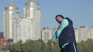 Back view of fit men stretches muscles before morning jog outdoors video