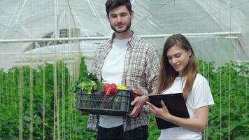 tipo Lavorando su il raccogliere e il ragazza agronomo sorridente direttamente a il telecamera video