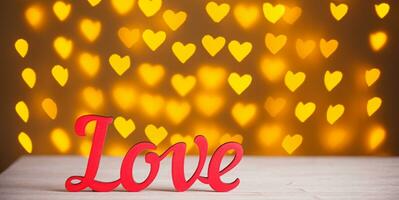 the inscription Love on a wooden background with beautiful hearts made of lights on a blurred background photo