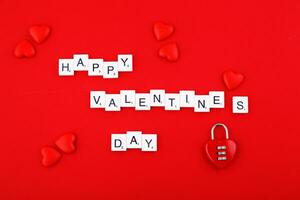 inscripción San Valentín día y rojo corazones en un rojo antecedentes foto