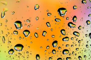 Beautiful multi-colored water droplets on a glass photo