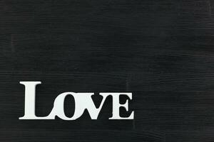 inscription I love you on a black wooden background photo