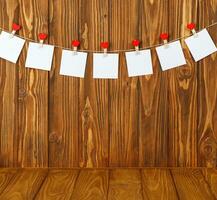 white pieces of paper on clothespins with a heart on a wooden background photo