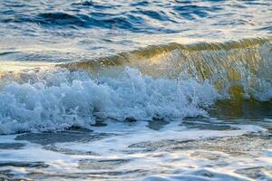 a wave is breaking on the beach photo