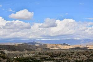 the landscape of the desert with clouds and mountains photo