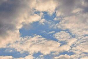 un azul cielo con nubes y un avión volador en el cielo foto
