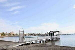 a pier with a boat dock and a small house on the beach photo