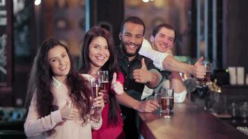 un' gruppo di amici a il bar con un' birra sorridente e mostrando pollice su video