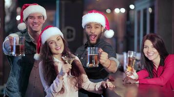 tre amici nel Santa cappelli e il ragazza dietro a il bar con un' bicchiere di birra video