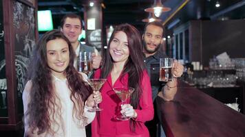 muchachas con martini y chicos con lentes de cerveza a el bar saluda amigos video