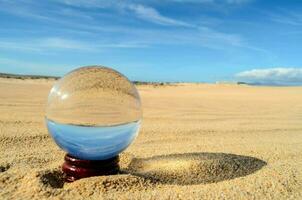 a glass ball in the sand photo