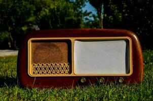 an old fashioned radio sits on the grass photo