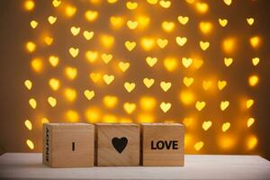 wooden cubes I Love You on a blurred background of hearts photo