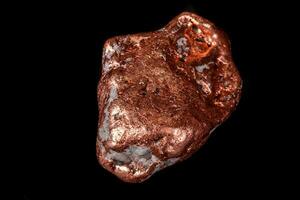 Macro mineral stone of a copper nugget on a microcline on a black background photo