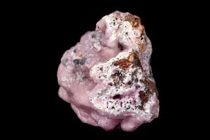 Macro pink Smithsonite mineral stone on microcline on black background photo